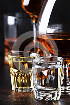 Selection of hard alcoholic drinks in big glasses and small shot glass in assortent: vodka, rum, cognac, tequila, brandy and