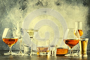 Selection of hard strong alcoholic drinks in big glasses and small shot glass in assortent: vodka, cognac, tequila, brandy and photo