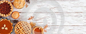 Selection of homemade autumn pies, corner border on a white wood background