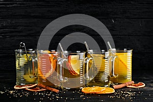 A selection of hot cocktails. Winter drinks. Hot wine. On a black wooden background.