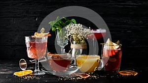 A selection of hot cocktails. Winter drinks. Hot wine. On a black wooden background.