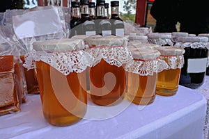 Selection of jars of honey with lacy tops displayed at a villag