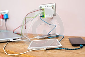 Selection Of Mobile Phones Digital Tablet And Laptop Computer Being Charged At Home