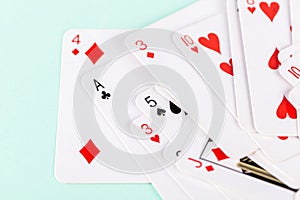 Selection of playing cards in disarray against a soft green background. Leisure games, entertainment and pastime activities