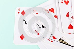 Selection of playing cards in disarray against a soft green background. Leisure games, entertainment and pastime activities photo