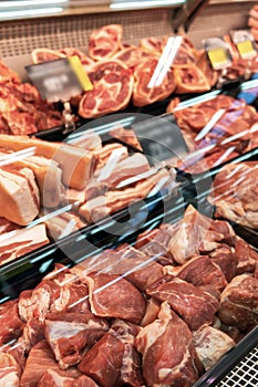 Selection of quality meat at a butcher shop, beef and pork, ham, vertical photo