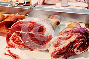 Selection of quality meat in a butcher shop. Raw pork knuckles are on display. Meat assortment