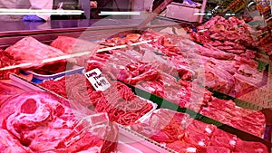 A selection of raw red meat on display in a supermarket