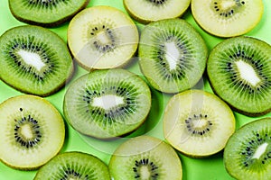 Selection of slices of yellow and green kiwi fruit on a bright high contrast green background