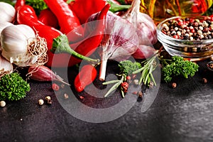 Selection of spices herbs and greens. Ingredients for cooking. Food background on black slate table