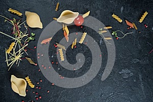 Selection of spices herbs and greens. Ingredients for cooking. Food background on black slate table.