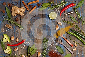 Selection of spices, herbs and greens on vintage blue wooden background. Ingredients for cooking. Wooden background, top view, co
