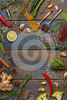 Selection of spices, herbs and greens on vintage blue wooden background. Ingredients for cooking. Wooden background, top view, co