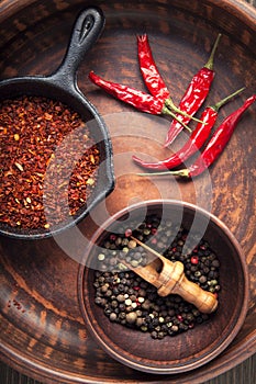 Selection of spices pepper. Food background on black wood table.