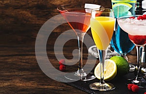 Selection of summer cocktails. Cold refreshing alcoholic beverages and drinks: mimosa, cosmopolitan, raspberry margarita and blue