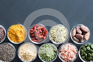 Selection of superfoods on a black background with copy space