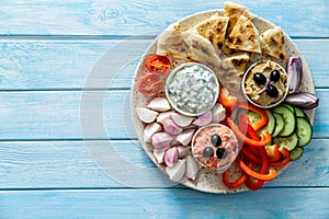 Selection of traditional greek food - salad, meze, pie, fish, tzatziki, dolma on wood background