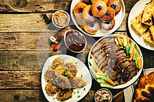 Selection of traditional hanukkah food for festive dinner, wood background