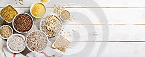 Selection of whole grains in white bowls - rice, oats, buckwheat, bulgur, porridge, barley, quinoa, amaranth,