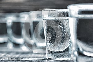 Selectiv focus glasses of vodka on wooden table