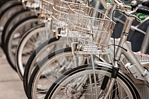 Selective blur on bicycles and their wheels, parked in row in a rent a bike station