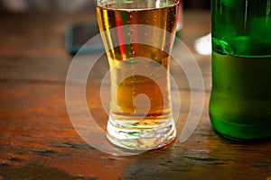 Selective blur on a Closeup on a beer mug containing a light beer, pilsner lager style, served in a standard pint size glass