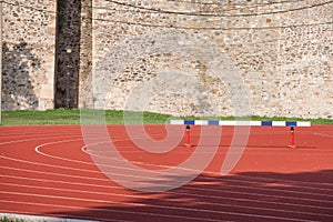 Selective blur on the curve on a running track, with a hurdle used for hurdling om athletics field used for athletism competition photo