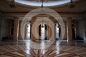 Selective blur on giant windows and opulent design of a hall in the interior of the Romanian palace of parliament in Bucharest, a