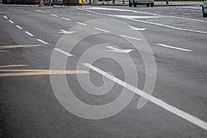 Selective blur on lane markings with painted directional arrows on thru lanes on asphalt, on a city urban road used for traffic