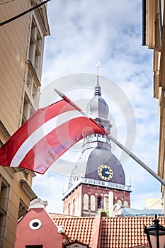 Selective blur on a latvian flag waiving in the sky in Riga old town, vecriga. The flag of Latvia, or Latvijas karogs, is the photo