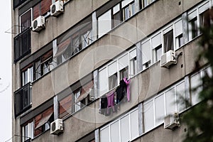 Selective blur on laundry clothes handing and drying at the window of a typical easter european communist building, in Serbia,