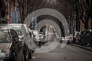 Selective blur on lines of cars parked in the city center of Belgrade, Serbia, on a residential street where vehicles