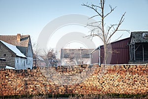 Selective blur on a old brick wall, red bricks, decaying and cracked, in a serbian village of vojvodina in a rural countryside