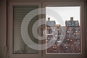 Selective blur on PVC windows, in plastic, one covered with roller shutters, in an urban environment of Serbia with residential