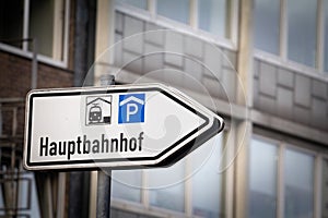 Selective blur on a roadsign indicating the direction to Hauptbahnhof, meaning Main train station in German, in aachen hbf, a