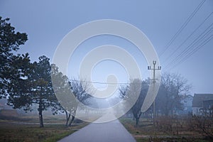 Selective blur on an smoggy foggy empty road street in the village of Vladimirovac in Vojvodina, Banat, Serbia, in the countryside