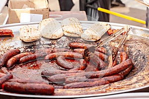 Selective blur on traditional serbian sausages cooking being grilled, called srpska domaca kobasica, cooking in a market at a photo