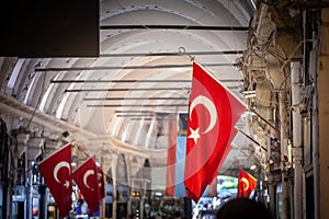 Selective blur on Turkish flags hung in the grand bazaar. Also known as kapalicarsi, it is one of the main landmarks and touristic