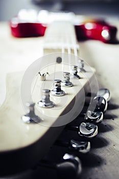 Selective closeup shot of a tailpiece of a white and red electric guitar