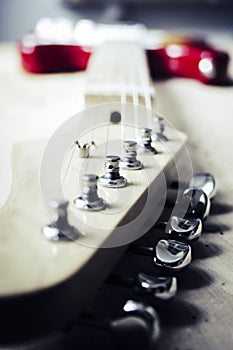 Selective closeup shot of a tailpiece of a white and red electric guitar photo