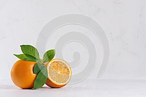 Selective colorful oranges with green foliage on white modern kitchen interior.