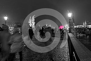 A selective colour scene of tourists dashing about in the snow,