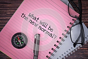 Selective ficus image of spectacles, compass and pen with What will be the new normal wording. New normal concept