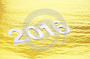 Selective focus or 2016 number over golden background