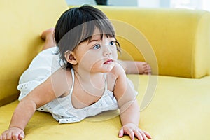 Selective focus adorable caucasian little baby daughter girl, crawling on sofa, playing in comfortable living room at home or