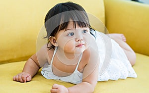 Selective focus adorable caucasian little baby daughter girl, crawling on sofa, playing in comfortable living room at home or