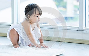 Selective focus adorable caucasian little baby daughter girl, smiling, crawling on the floor, playing alone in comfortable living