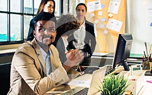 Selective focus adult smart African black smart businessman wearing formal suit, looking at camera, standing in indoor modern