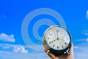 Selective focus of alarm clock with blue sky