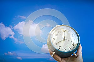 Selective focus of alarm clock with blue sky